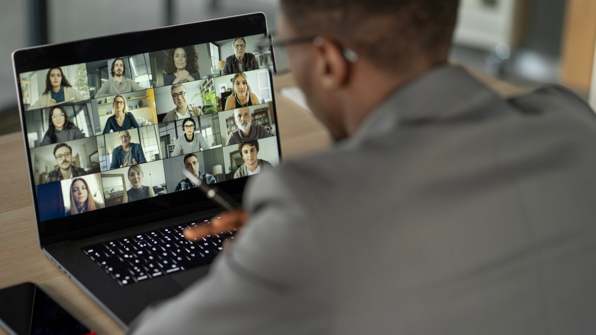 Man sitting at desk participating in an online meeting.