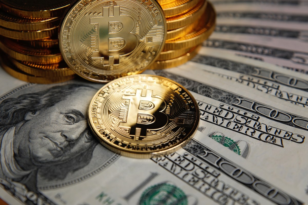 Bitcoin coins cryptocurrency on U.S. dollar banknotes background.