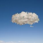 Image of money floating in a cloud against a blue sky.